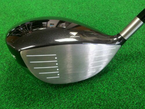 A golf club with the head of it on a green.