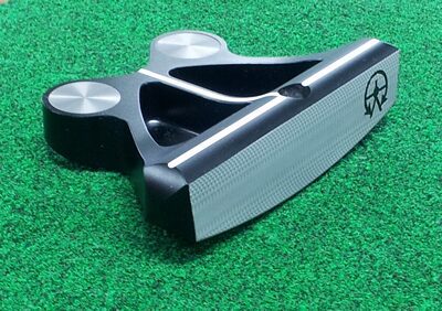 radius sole Black and gray golf putter on green.