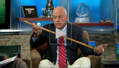 Man holding golf club and ball.