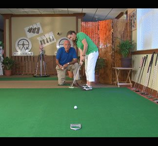 Here's an alt tag for the image: Golf instructor helping student putt.