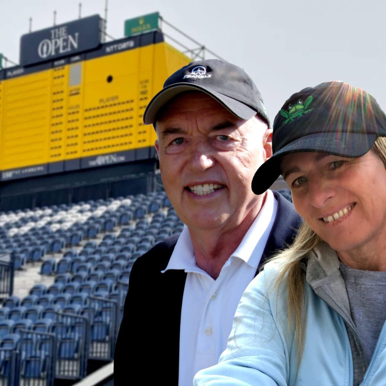 A man and woman posing for the camera in front of an empty stadium.